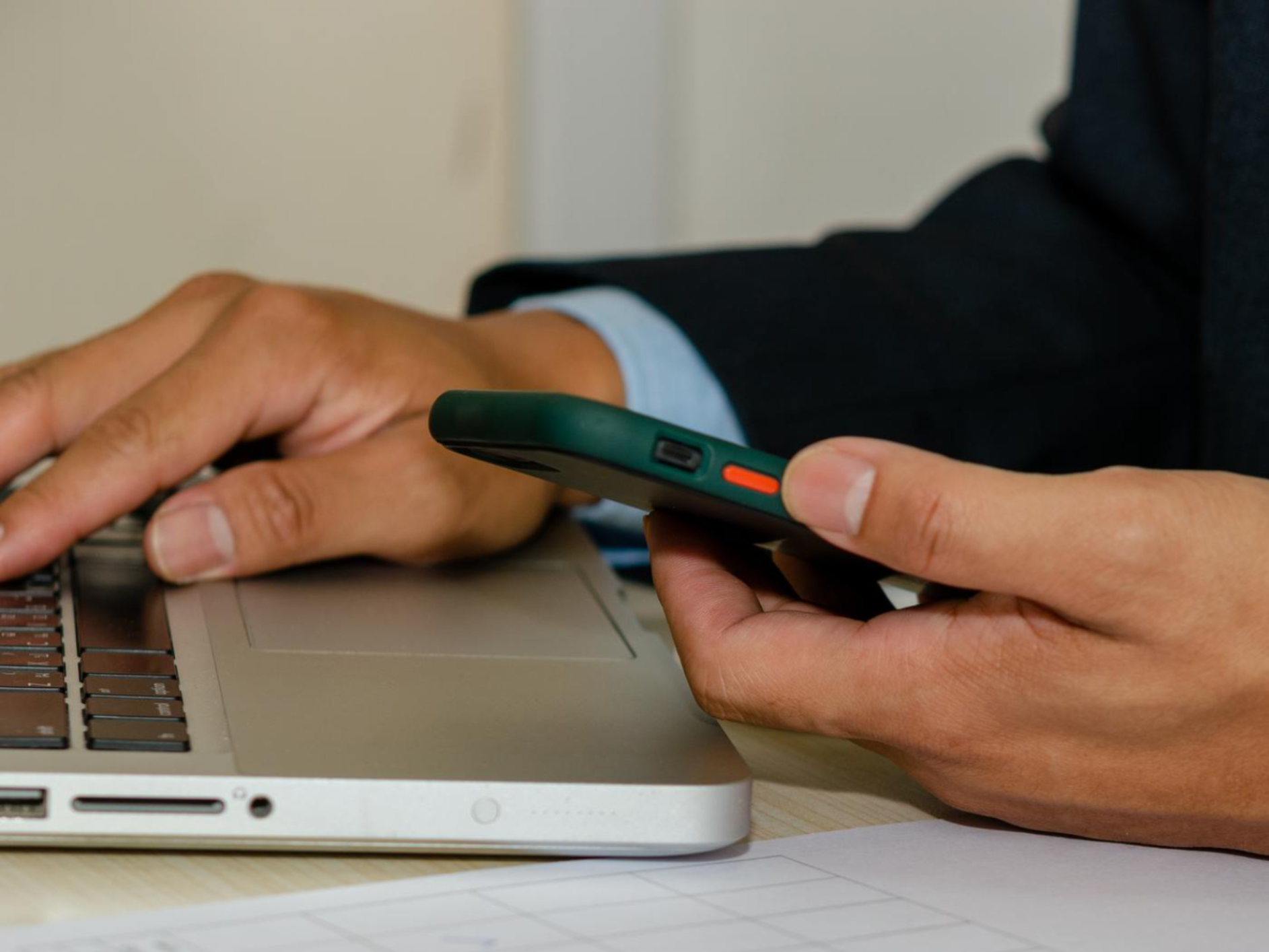 Segure um telemóvel e olhe para o computador e documentos de avaliação de satisfação de negócios na mesa